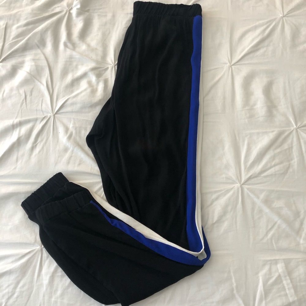 Black flowy pants with white and blue stripes on the sides